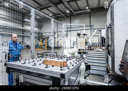 Wartungstechniker beobachtet Roboterarm in einer modernen Fabrik Stockfoto