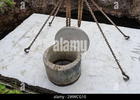 Klärgrube aus Beton mit einer Kapazität von 10 m3 im Garten neben dem Haus, sichtbare Abdeckung mit Mannloch. Stockfoto