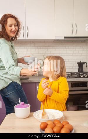Großmutter und Enkelin machen Kuchen in der Küche, glückliche Familie, Frau und Kind lächeln. Spaß haben Stockfoto
