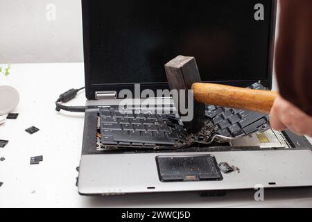 Ein Büroangestellter zerschlug einen Laptop, zerstörte einen Computer. Wut, Hass, Irritation. Fehler, Bremse, Störung, will nicht funktionieren. Schlechte Emotionen. De Stockfoto