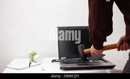 Ein Büroangestellter zerschlug einen Laptop, zerstörte einen Computer. Wut Hass, Irritation. Fehler, Bremse, Störung, will nicht funktionieren. Schlechte Emotionen. abt. Stockfoto