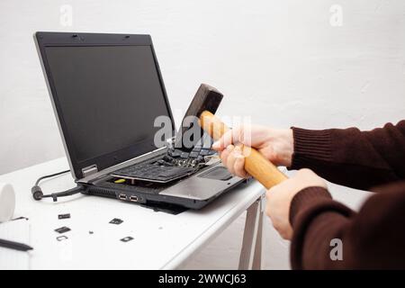 Ein Büroangestellter zerschlug einen Laptop, zerstörte einen Computer. Wut Hass, Irritation. Fehler, Bremse, Störung, will nicht funktionieren. Schlechte Emotionen. abt. Stockfoto