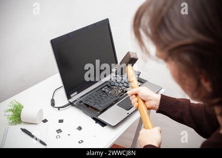 Ein Büroangestellter zerschlug einen Laptop, zerstörte einen Computer. Wut Hass, Irritation. Fehler, Bremse, Störung, will nicht funktionieren. Schlechte Emotionen. abt. Stockfoto
