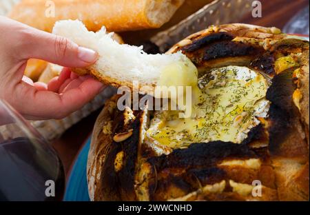 Camembert Fondue in Brotschale Stockfoto