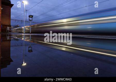 Der TransPennine Express-Zug der Klasse 802 fährt durch den Bahnhof Edge Hill, Merseyside bei Nacht mit Bewegungsunschärfe Stockfoto