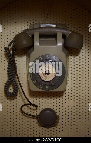 Altes braunes Telefon an der Peg Board Wand Stockfoto