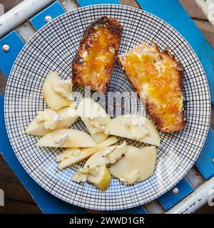 Käse auf Apfelscheiben mit Brot, Butter und Marmelade Stockfoto