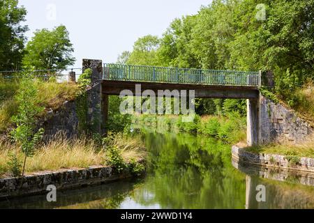 Schmale Brücke über einen Calm River Stockfoto