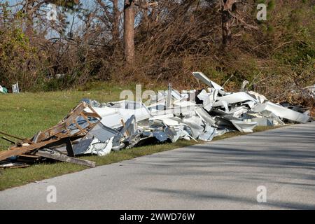 Müllhaufen auf der Straßenseite von stark beschädigten Häusern nach dem Hurrikan in Florida Wohnmobilgebiet. Folgen von Naturkatastrophen Stockfoto