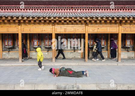 Pilger beugten sich auf den Gebetsmühlen um das Kloster Labrang. Xiahe County, Gannan, Autonome Tibetische Präfektur, Gansu, China Stockfoto