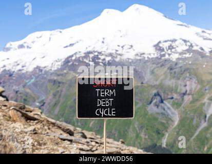 Symbol für den kurzfristigen Schuldenzyklus. Konzeptworte kurzfristiger Schuldenzyklus auf wunderschöner schwarzer Kreidetafel. Wunderschöner Berg Elbrus Hintergrund. Unternehmen Stockfoto