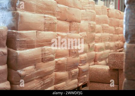 Im Lager der Fabrik liegen vakuumverpackte Holzspeile auf Paletten Stockfoto