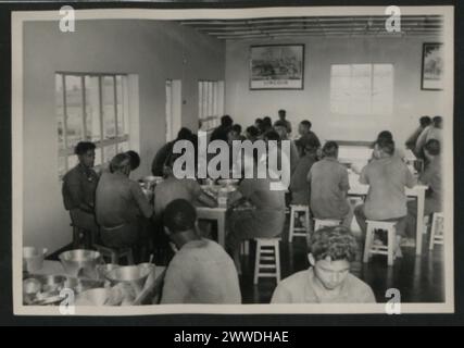 Beschreibung: Richelieu Rehabilitationszentrum. Der Speisesaal wird genutzt. Gefangene essen in Chaos von acht und einer der acht serviert das Essen aus der Serviceleiste der angrenzenden Küche. Ort: Richelieu, Mauritius Datum: 1950-1959 Stockfoto