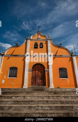 Niedrigwinkelaufnahme einer lebendigen orangefarbenen Kolonialkirche mit Steinstufen, Granada, Nicaragua Stockfoto