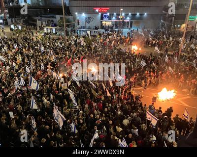 Tel Aviv, Israel. März 2024. Verwandte und Unterstützer israelischer Geiseln, die von der islamistischen Hamas im Gazastreifen festgehalten werden, blockieren eine Straße während einer Kundgebung, die ihre Freilassung fordert. Sie protestieren auch gegen die Regierung und fordern neue Wahlen. Quelle: Cindy Riechau/dpa/Alamy Live News Stockfoto