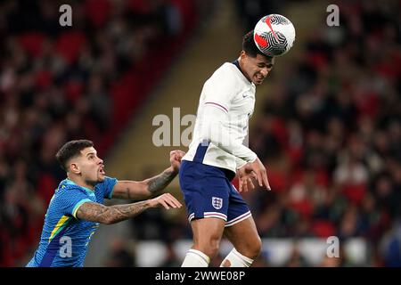 Der Engländer Jude Bellingham (rechts) und der Brasilianer Bruno Guimaraes kämpfen während des internationalen Freundschaftsspiels im Wembley Stadium in London um einen Kopfball. Bilddatum: Samstag, 23. März 2024. Stockfoto