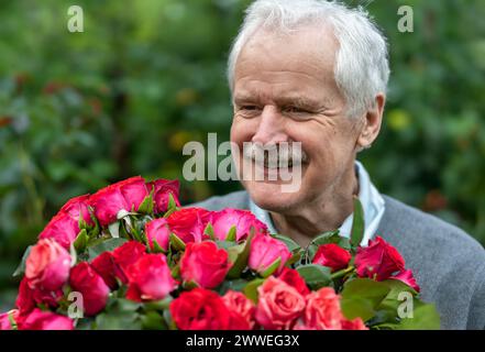 Senior Mann mit einem Rosenstrauß. Symbol für ein Datum in einem höheren Alter. Stockfoto