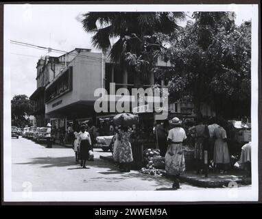 Straße vor der unteren grünen Bushaltestelle in Bridgetown, Barbados, Straße, Gebäude, Fahrzeuge, und Stadtplanung 1960. Stockfoto