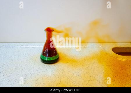 Chemisches Experiment, bei dem Salpetersäure (HNO3) in einen Erlenmeyerkolben mit Kupferspänen gegeben wird, wodurch eine heftige chemische Reaktion ausgelöst wird. Stockfoto