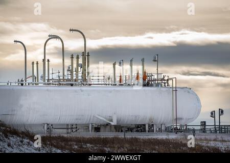 Cochrane Alberta Canada, 6. Februar 2024: Große Tanks in einer Industriegasanlage unter bewölktem Abendhimmel Stockfoto