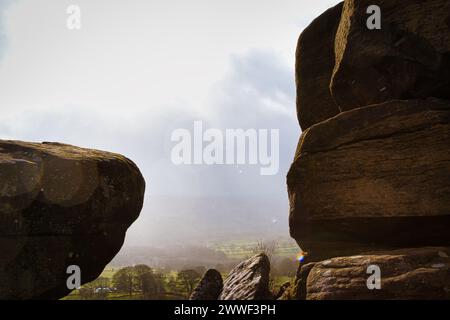 Malerische Aussicht auf eine Landschaft durch Felsformationen unter bewölktem Himmel bei Brimham Rocks in North Yorkshire Stockfoto