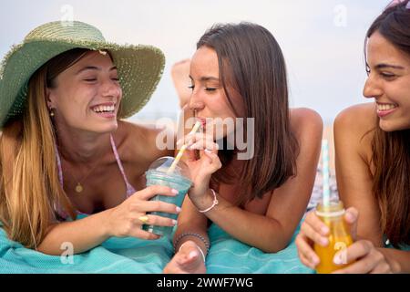 Porträtgruppe attraktiver kaukasischer Frauen, die lächeln und natürliche Smoothies halten und trinken Stockfoto
