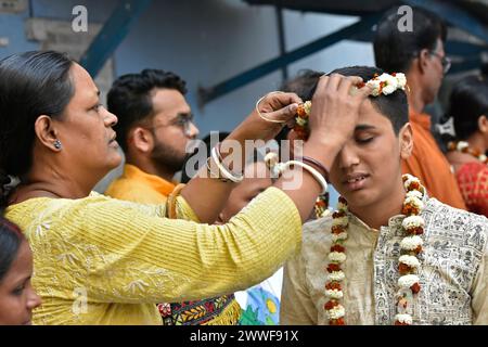 Kalkutta, Indien. März 2024. Die Mutter eines blinden Schülers schmückt ihn mit Blumen, bevor sie Flower Holi in Kalkutta aufführt. (Foto: Suraranjan Nandi/Pacific Press) Credit: Pacific Press Media Production Corp./Alamy Live News Stockfoto