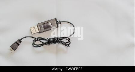 Ein gewickeltes USB-Kabel mit Metallakzenten auf weißem Hintergrund in Südkorea Stockfoto