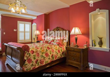 Hölzernes Schlittenbett und Nachttisch im Hauptschlafzimmer im Obergeschoss im eleganten Haus, Quebec, Kanada Stockfoto