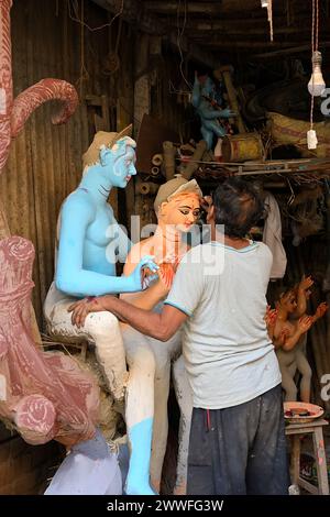 Ein Handwerker, der an einem Tonbild der Göttin Durga arbeitet, in einer Werkstatt in Kumartuli, einem alten Viertel in Kalkutta, wo eine Gemeinschaft von Götzenmachern lebt Stockfoto