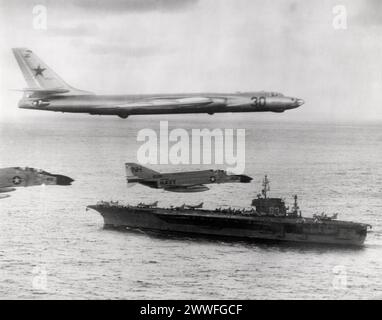 Pazifik, Januar 1963 zwei F-4 Phantom II Kampfflugzeuge der US Navy eskortieren einen sowjetischen Badger, der über ihr Schiff, den Angriffsträger USS Kitty Hawk (CVA-63), im Nordpazifik flog. die sowjetischen Flugzeuge wurden zu und vom Träger begleitet und während der Zeit, als sie sich in der Nähe des Schiffes aufhielten, unter Beobachtung gehalten. Stockfoto