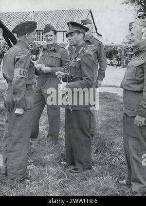 Ein Foto zeigt König Georg VI., der 1940 mit den neu entwickelten Local Defence Volunteers (LDV), später als Home Guard bekannt, interagierte. Dieses Bild unterstreicht die Beteiligung und Unterstützung des Königs für diesen entscheidenden Teil der britischen Innenverteidigung während des Zweiten Weltkriegs und zeigt sein Interesse an den innovativen Ansätzen zum Schutz der Heimatfront. Stockfoto