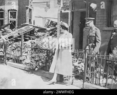 Ein Foto zeigt Königin Elisabeth I. (die Königin Mutter) und König Georg VI., die nach dem Blitz 1940 in Hull, England, ein schwer beschädigtes Haus verlassen haben. Dieses Bild zeigt die direkte Auseinandersetzung des königlichen Paares mit den verheerenden Auswirkungen der Bombenangriffe auf britische Städte im Krieg. Ihr Besuch in Hull, einem der vielen während des Zweiten Weltkriegs schwer betroffenen Gebiete, unterstreicht ihr Engagement, ihre Unterstützung und Solidarität mit ihrer Bevölkerung in Zeiten der nationalen Krise zu zeigen. Stockfoto