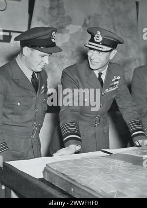 Ein Foto zeigt König George VI. Mit dem Wing-Commander Guy Gibson, der im Mai 1943 von der erfolgreichen RAF-Bomberangriff auf die großen Ruhrdämme zurückkehrte. Dieser Moment erinnert an die strategische und gewagte Operation Chastise, die im Zweiten Weltkrieg das industrielle Kernland Deutschlands erheblich beeinflusste. Stockfoto