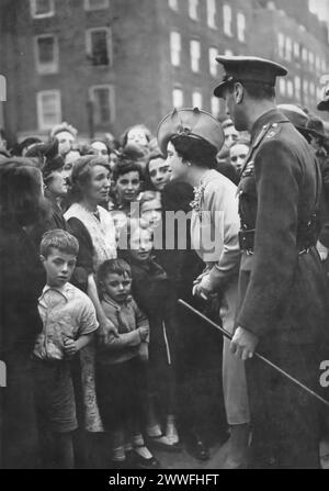 Ein Foto zeigt König Georg VI. Und Königin Elisabeth I. (die Königin Mutter), die mit den Menschen in London interagieren, die von dem Londoner Bombenanschlag betroffen waren, bekannt als der Blitz, um 1940. Dieses Bild zeigt das Engagement der Monarchen für ihr Volk während einer der dunkelsten Zeiten Großbritanniens, als sie durch die Öffentlichkeit gingen und Unterstützung und Solidarität anboten und die Widerstandsfähigkeit und Einheit der Nation während des Zweiten Weltkriegs verkörperten Stockfoto