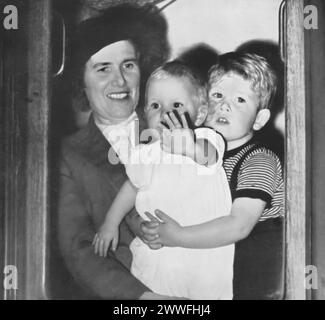 Foto von Helen Lightbody, der Prinzessin Anne hält, während ein junger Karl III. Seine Schwester umarmt. Dieses Bild wurde 1951 aufgenommen und zeigt die Geschwister, die darauf warten, mit ihren Eltern wieder vereint zu werden, und bietet einen Einblick in die frühe Kindheit des zukünftigen Königs Karl III. Und seiner Schwester. Stockfoto