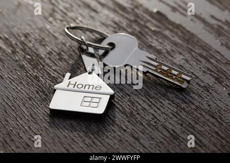 Haussymbol mit silbernen Schlüsseln auf abstraktem Hintergrund. Immobilienkonzept Stockfoto