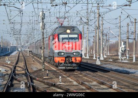 PETRO-SLAVYANKA - 4. MÄRZ 2024: Personenzug 'St. Petersburg - Moskau' mit Elektrolokomotive EP2K an einem sonnigen Märztag. Oktjabrskaja Eisenbahn Stockfoto