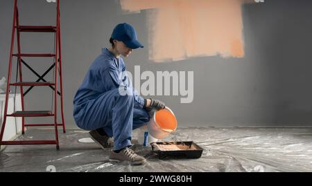 Ein Maler gießt beige Farbe aus einem Eimer in ein Tablett. Das Konzept der Reparatur und Bemalung von Wänden in einem Haus Stockfoto