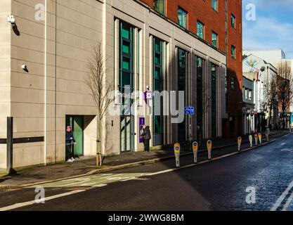 Belfast County Antrim Nordirland 23. Februar 2024 - ruhige Straße im Stadtzentrum mit einem Mann am Geldautomaten und einem Handy Stockfoto