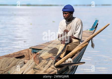 Ein Fischer repariert ein Netz am Ufer des Chilwa-Sees im Machinga-Bezirk von Malawi. Trocaire und seine lokalen Gruppen helfen den Einheimischen, den Chilwa-See zu patrouillieren, um sicherzustellen, dass es keine illegale Fischerei gibt. Im Jahr 2015 trocknete der See aufgrund des Klimawandels vollständig aus, was zum Verlust der meisten Fischarten führte, wodurch eine andere lebenswichtige Nahrungsquelle stärker unter Druck gesetzt wurde. Bilddatum: Dienstag, 5. März 2024. Stockfoto