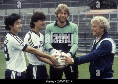 Karl-Heinz Feldkamp Re. mit Arminia-Spielern 07/83 stroe Karl-Heinz Feldkamp Re. mit Spielern am Rande eines Mannschaftsfototermins des DSC Arminia Bielefeld am 14. Juli 1983 auf der Alm in Bielefeld, v.li.: Kazuo Ozaki, Matthias Westerwinter und Wolfgang Kneib Deutschland deutsch deutscher Mann Männer Fans Fußball Sport Sportler Fußballspieler Fußballtrainer Bundesliga Liga Bielefelder Torwart Torhüter deutscher Fußballtrainer quer halb stehend sprechend lächelnd lachend Profil Ball hält Seidensticker Sponsor Adidas *** Karl Heinz Feldkamp rechts mit Arminia-Spielern 07 83 stroe Karl Hei Stockfoto