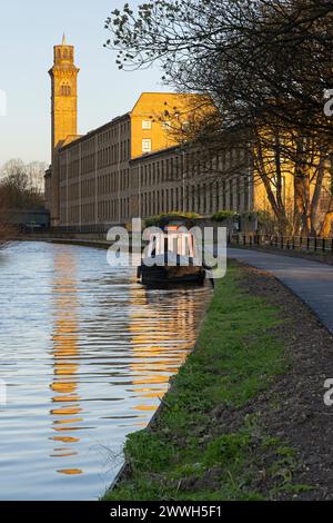 Der Italianate Tower von New Mill, Saltaire, spiegelt sich im Wasser des Leeds-Liverpool Canal in der Nähe von Bradford, West Yorkshire Stockfoto