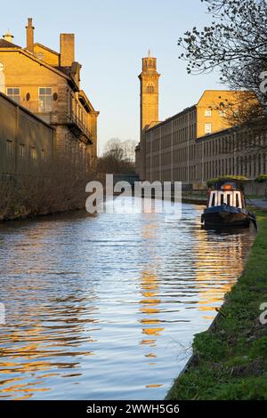 Der Italianate Tower von New Mill, Saltaire, spiegelt sich im Wasser des Leeds-Liverpool Canal in der Nähe von Bradford, West Yorkshire Stockfoto