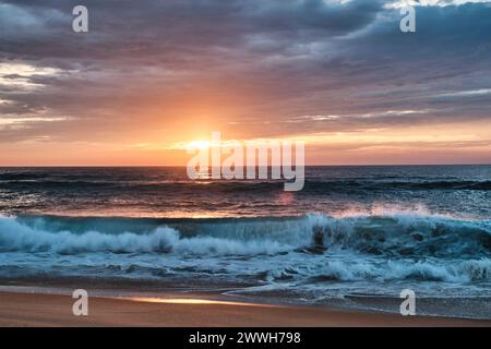 Wellen des altlantischen Ozeans brechen auf den Strand an der cote de Argent in Frankreich mit goldenem Sonnenuntergang im Hintergrund, Cap Ferret, Aquitaine, Fran Stockfoto