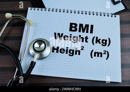 Konzept des BMI - Gewicht und Höhe schreiben auf Buch isoliert auf Holztisch. Stockfoto