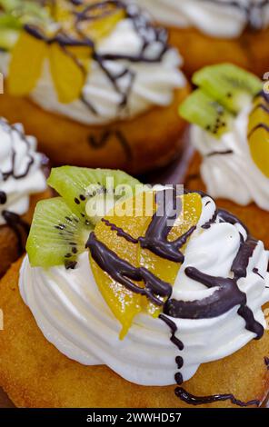 Gruppe von Kuchen dekoriert mit Buttercreme, frischem Obst und Schokolade Stockfoto