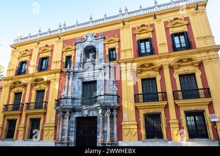 Bischofspalast (Palacio Episcopal, Bischofspalast) auf dem Obispo-Platz, Malaga, Andalusien, Spanien mit farbenfroher gelb-roter spanischer Barockfassade. Stockfoto