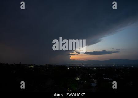 Ein Blitz fällt über die Stadt Port-au-Prince, Haiti, mit dramatischen Wolken auf der einen Seite und einem farbenfrohen Sonnenuntergang auf der anderen Seite Stockfoto