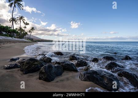 Wellen vom Pazifischen Ozean ziehen sanft über vulkanische Felsen am Kaanapali Beach in Lahaina, Hawaii auf der Insel Maui. Stockfoto